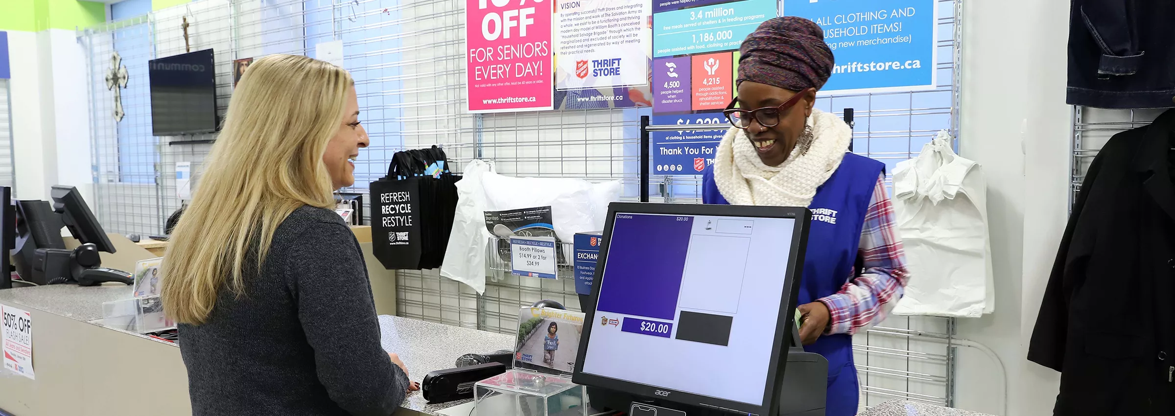 A retail store checkout counter featuring a customer interacting with a cashier. The setting includes promotional signage, clothing items on display, and a point-of-sale system. Visible text includes '10% OFF FOR SENIORS EVERY DAY' and other promotional details. The environment suggests a casual shopping experience.